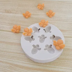 Detailed view of a white 7-cavity bee silicone mold with finished orange bee shapes