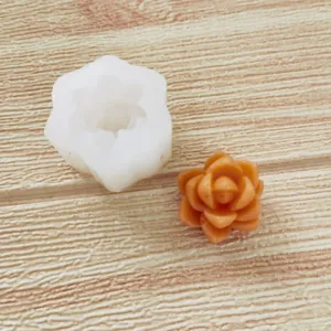 Nahaufnahme einer weißen Silikonform für Rosen mit einer fertigen orangefarbenen Blume.