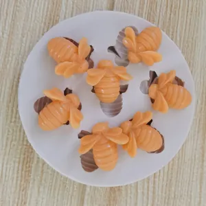 Detail view of 7-cavity bee-shaped silicone mold with yellow honeybee resin figures.