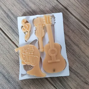Detail einer Silikonform für Musikinstrumente mit Schokoladen Geigen und Gitarren