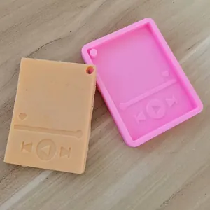 Detalle de un molde de silicona para reproductor MP3 y una pieza de resina terminada