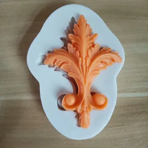 Detail of European relief silicone mold with orange acanthus leaf fondant decoration