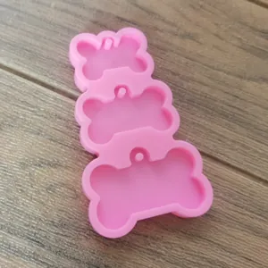 Dettaglio dello stampo in silicone rosa a 3 cavità a forma di osso per resina e ciondoli