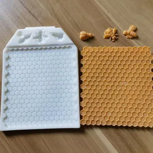 Detailed view of honeycomb and bee silicone mold with finished yellow fondant samples.
