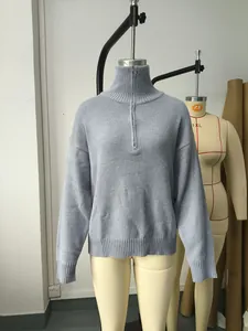 Detalle de un suéter de punto morado para mujer con cuello alto con cremallera y ribete