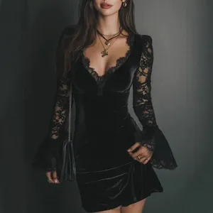 Detail of a black velvet mini dress with elegant lace sleeves and deep V-neckline.
