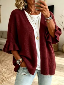 Primo piano di un cardigan bordeaux lavorato a maglia con polsini a volant e vestibilità ampia