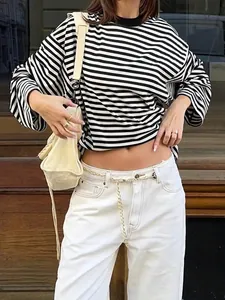 Close-up van oversized zwart-wit gestreepte top met lange mouwen in retrostijl.