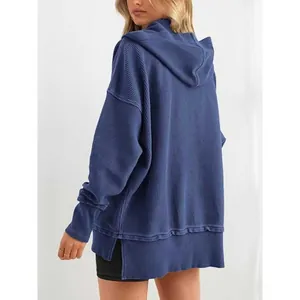 Vue arrière détaillée d'un sweat à capuche oversize bleu en maille gaufrée avec fentes latérales
