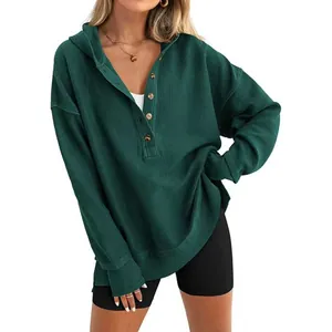 Détail d'un sweat à capuche côtelé vert pour femme avec boutons