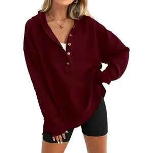 Gros plan d'un sweat à capuche bordeaux en maille gaufrée avec encolure boutonnée pour femme