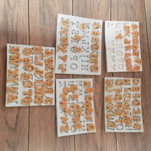 Dettaglio di cinque stili di stampi in silicone con lettere maiuscole per fondente e cioccolato