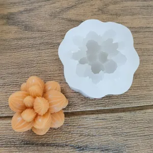 Detailed view showing the white silicone succulent mold and an orange wax finished product.