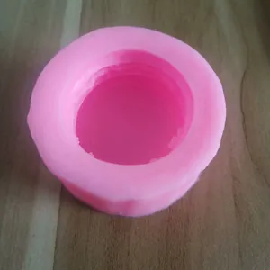 Bovenaanzicht van een roze ronde siliconen bakvorm voor macarons op houten blad