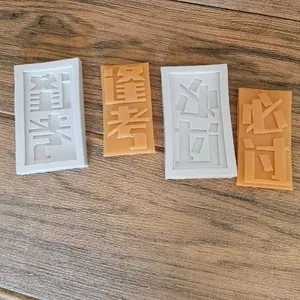 Détail montrant des moules en silicone et des pièces de fondant avec des caractères de réussite