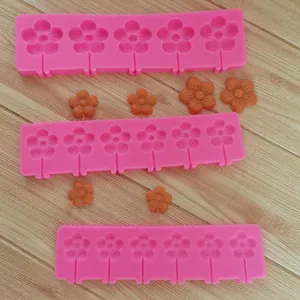 Close-up detail of pink flower lollipop silicone molds featuring orange finished products