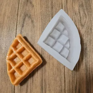 Gros plan d'un moule à gaufres en silicone blanc avec un modèle de gaufre fini