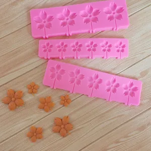 Set of three pink cherry blossom silicone molds with finished flower fondant decorations