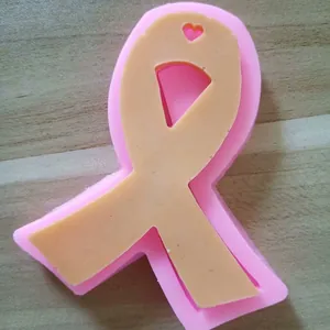 Close-up of pink ribbon-shaped silicone mold with a heart cutout