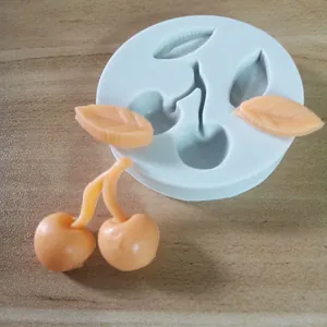 Primer plano de molde de silicona en forma de cereza con decoraciones de resina melocotón