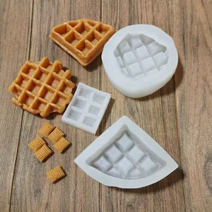 Divers moules à gaufres en silicone avec échantillons de desserts sur fond de bois