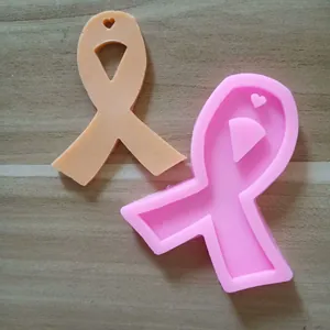 Close-up of pink awareness ribbon silicone mold and a peach-colored resin sample piece