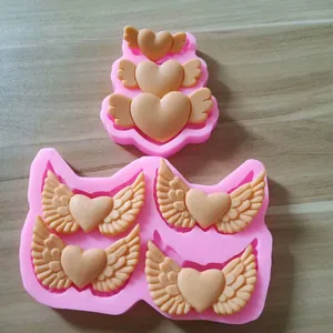 Detail view of pink silicone mold for winged heart chocolate and cake decorations.