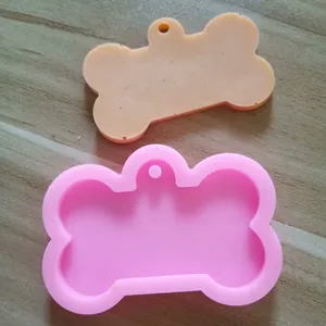 Detailaufnahme einer knochenförmigen Silikonform und eines Anhängers aus Harz