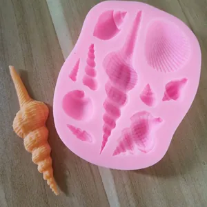 Primo piano di uno stampo in silicone a conchiglia rosa con un pezzo di resina arancione