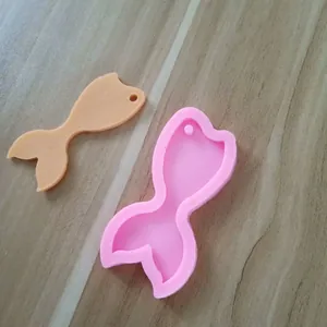 Vue détaillée d'un moule en silicone queue de sirène rose et pendentif en résine.