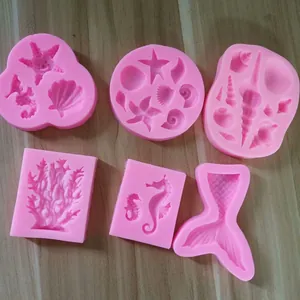 Dettaglio di stampi in silicone rosa a tema marino con conchiglie e stelle marine