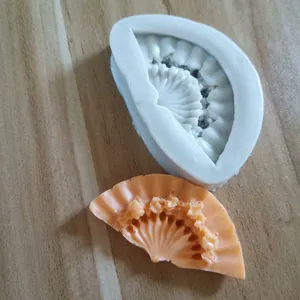 Detailed view of classical fan-shaped silicone baking mold with orange finished product result