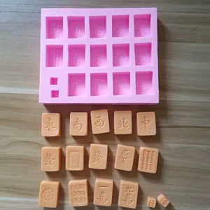 Detail view of pink silicone mahjong mold with cast orange chocolate tiles on wood surface