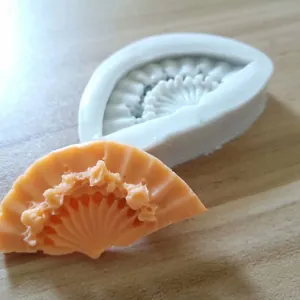 Detailed macro view of a classical fan-shaped silicone mold and peach wax sample