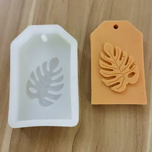 Detailed view of monstera leaf silicone mold and finished orange clay tag craft piece