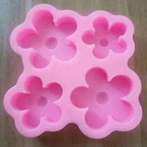 Détail montrant la forme de fleur à 5 pétales de ce moule de cuisson en silicone rose.