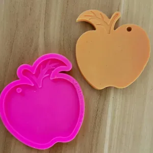 Detailansicht der Silikonform in Apfelform und des fertigen orangefarbenen Gussteils