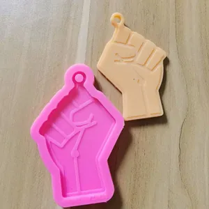 Close-up of fist-shaped silicone mold and finished resin keychain accessory