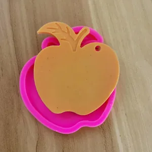 Silikonform in Apfelform für Harz-Schlüsselanhänger mit fertigem orangefarbenem Guss