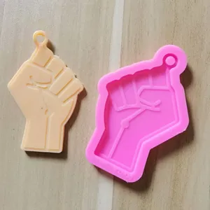 Detailed view of pink silicone mold and resin piece in the shape of a raised fist