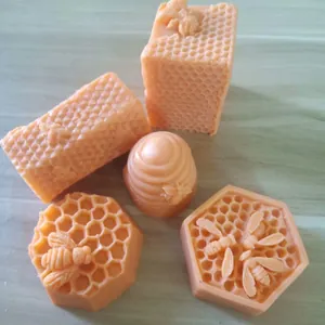 Vue détaillée de savons ou bougies orange en forme de nid d'abeille et d'abeille