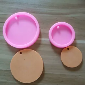 Detailed view of round pink silicone molds and orange cast samples for DIY resin crafts