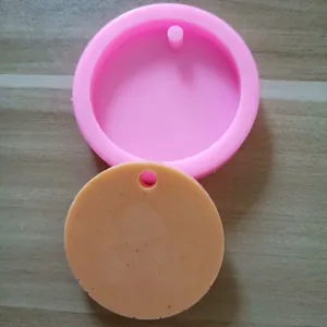 Detail view showing a round pink silicone mold alongside its orange circular cast piece