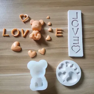 Detail view of heart, bear, and LOVE letter silicone molds with orange fondant samples