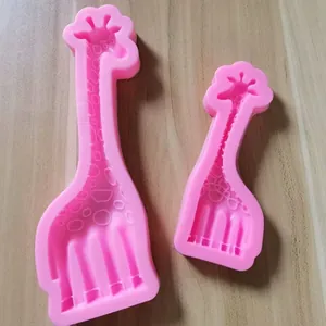 Macro view of pink giraffe-shaped silicone fondant molds on a wooden surface.