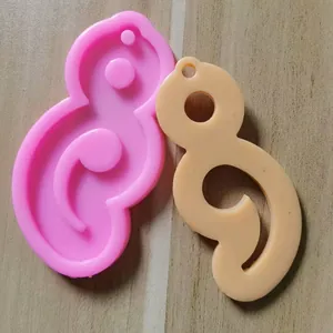 Detailansicht der Silikonform in Semikolon-Form und des fertigen Harz-Schlüsselanhängers.