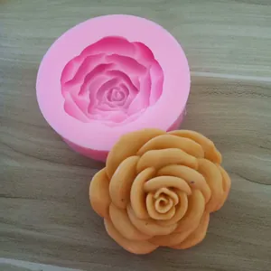 Detail view showing the pink silicone rose mold alongside a finished yellow wax flower