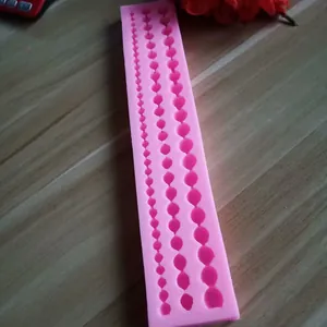 Close-up detail of a pink silicone baking mold with three sizes of pearl strand designs
