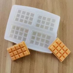 Detailed view of 4-cavity silicone chocolate mold with finished orange fondant bars