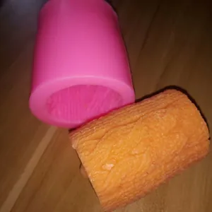 Gros plan du moule en silicone cylindrique rose avec texture de tricot et échantillon.